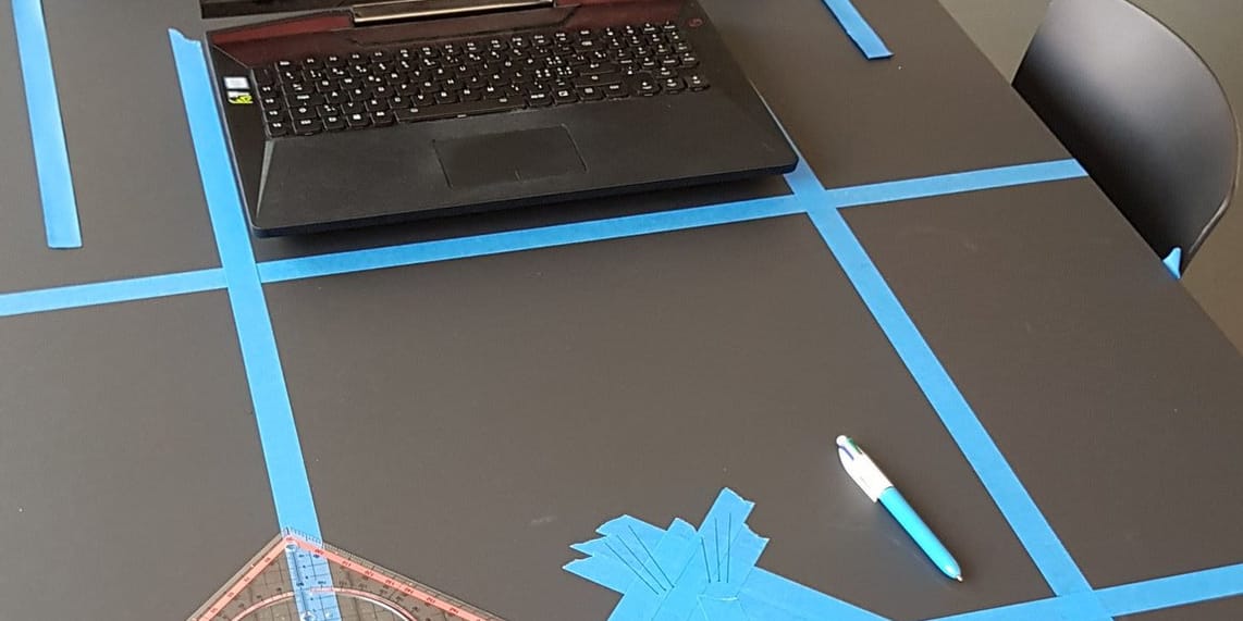 A laptop on a desk with tape